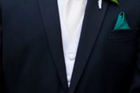 05 a black suit, a white shirt and tie, an emerald detail