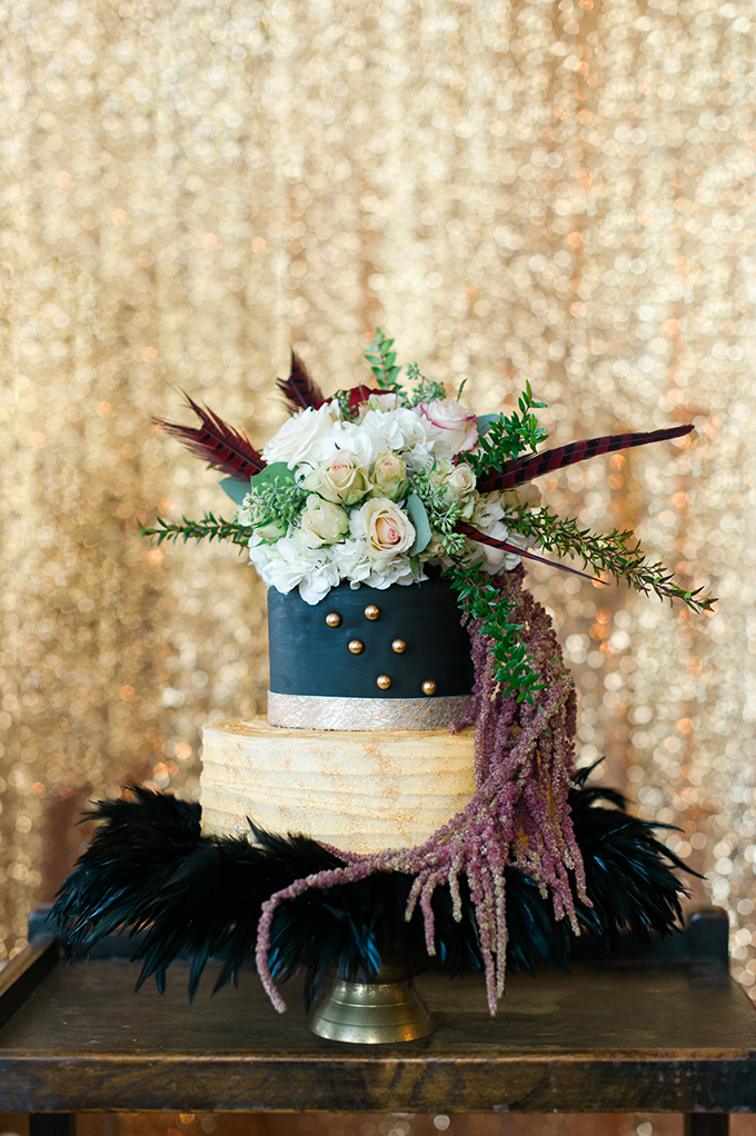 The wedding cake was done in black and half naked, with golden beads, topped with flowers and feathers