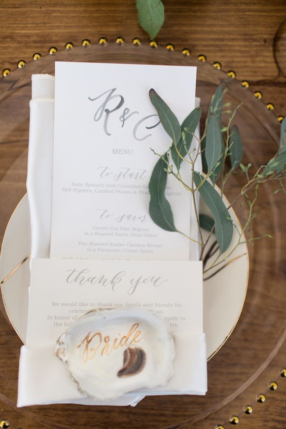hand-lettered gold oyster shell place cards, which guests can keep as a memento