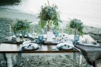 08 The wedding tablescape was done in blue and grey, with fishing net, blue glasses and greenery centerpieces on stands