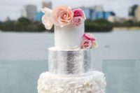 08 a white cake with a ruffled and a silver tier, bold flowers on top