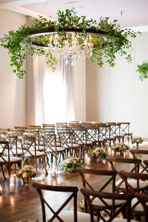 neutral florals for lining up the aisle and an oversized greenery chandelier