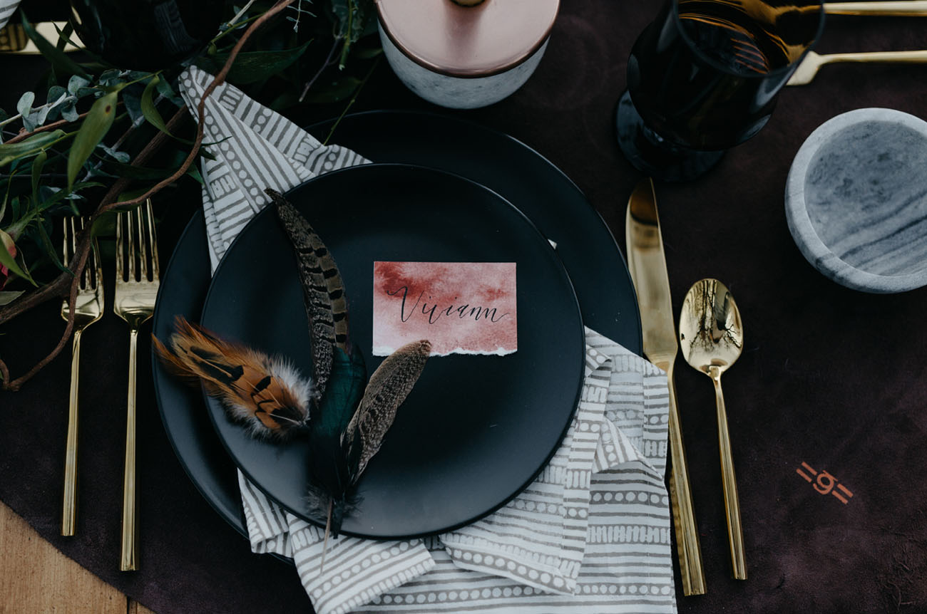 The place setting was decorated with watercolor cards, feathers and black plates