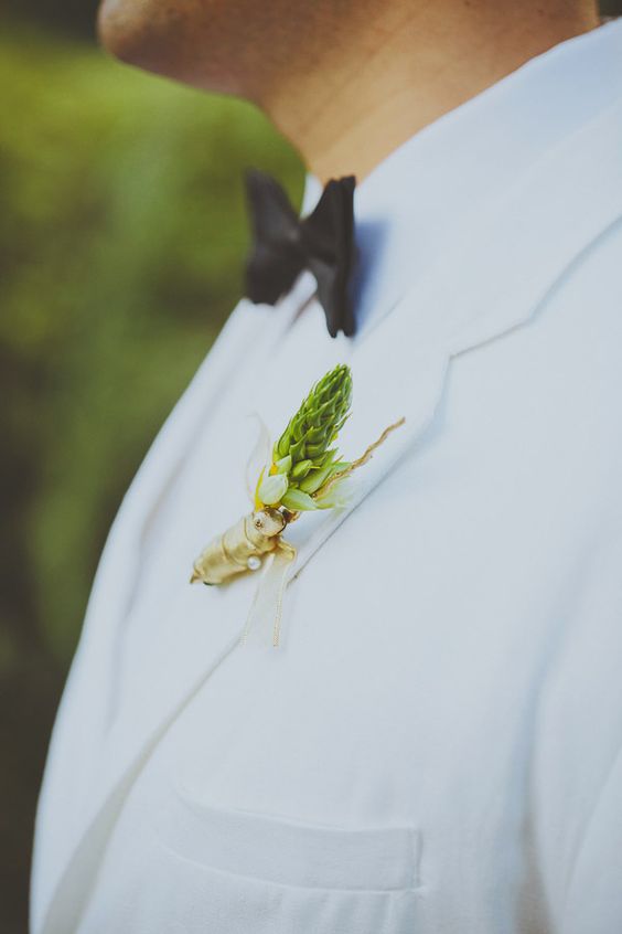 a white tuxedo with a black bow tie and a cute boutonniere