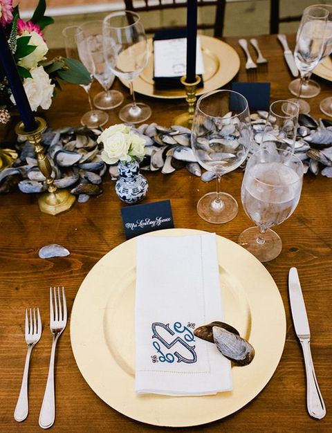 beautiful nautical table setting with an oyster garland, navy cards and flowers