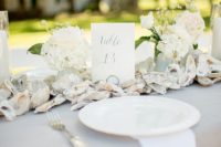 11 an oyster shell garland with white flowers are great for decorating a beach wedding table
