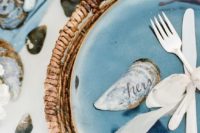 12 coastal wedding tablescape with a bold blue plate, a wicker platter and shells