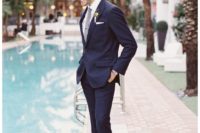 12 navy thin striped suit with a white shirt and a grey tie, ocher shoes and glasses