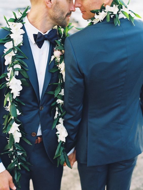navy blue suits, white shirts, bow ties and floral garlands for both grooms