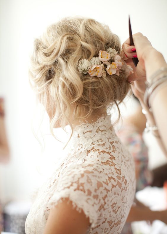 messy wedding updo with small neutral flowers