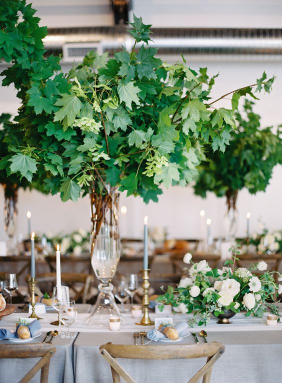 oversized greenery decor and smaller centerpieces with white flowers