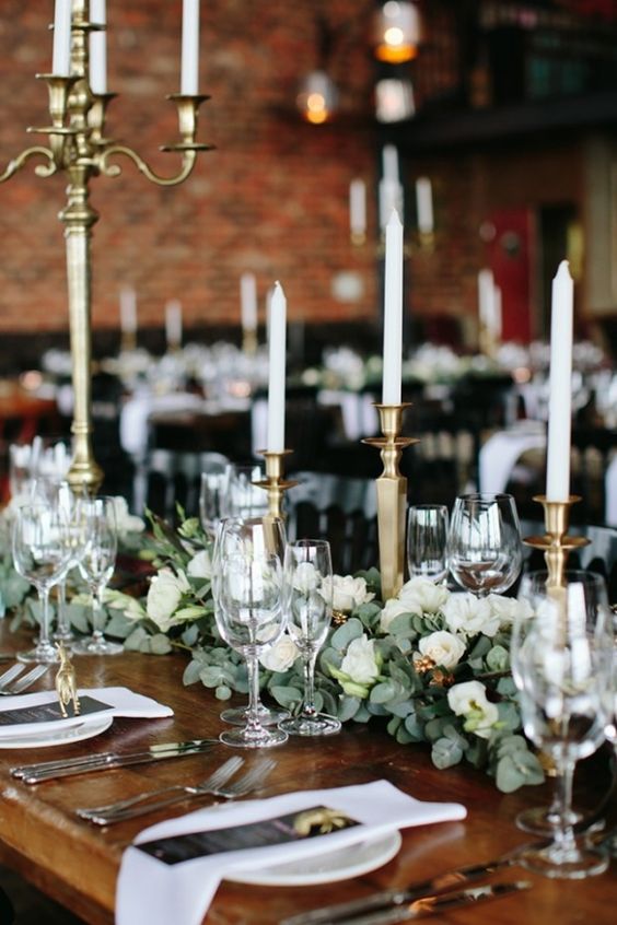 greenery and flower garlands on the table look awesome with gilded candle sticks