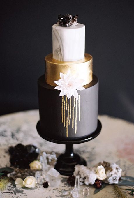 three-tiered black, gold and marble wedding cake with gems