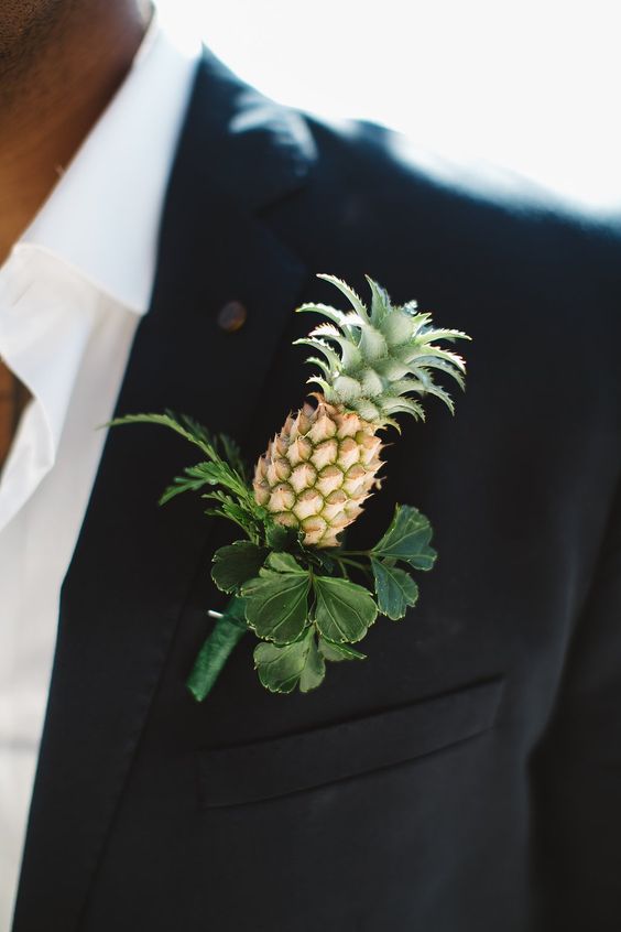 a black suit, a white shirt and a pineapple boutonniere