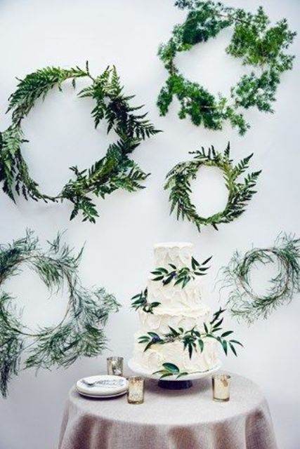 create a backdrop of greenery wreaths for your cake or dessert table