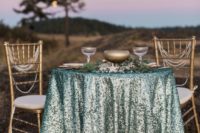 24 sweetheart table an aqua sequin tableclot, candles and some greenery