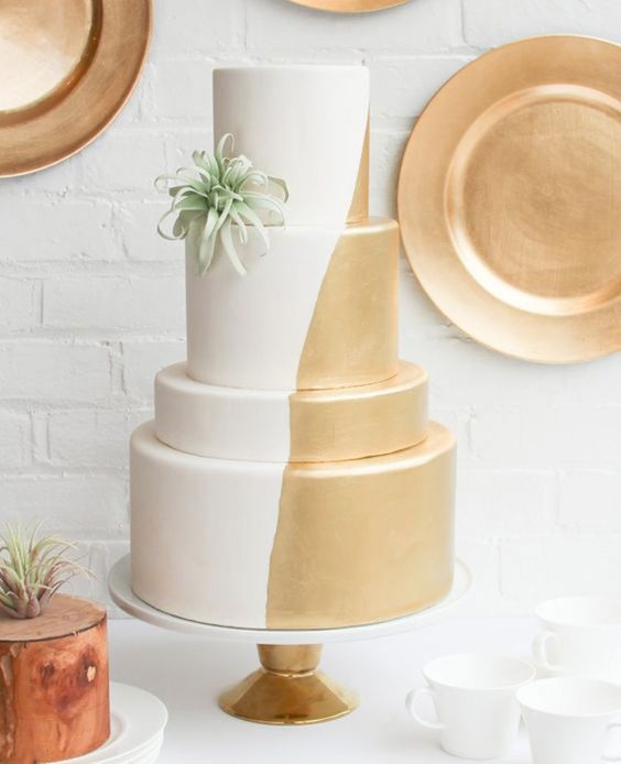 half gold and half white wedding cake with air plant decor for a modern wedding