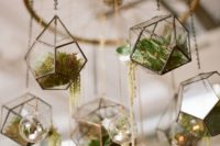 27 a wedding chandelier made of a large wheel and hanging terrariums filled with moss