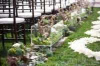 30 terrariums of moss succulents, diftwood and orchids lining wedding aisle