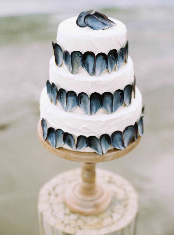 wedding cake covered with oyster shellls in a unique piece