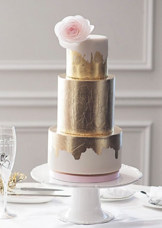 white and gold metallic wedding cake with a blush bloom