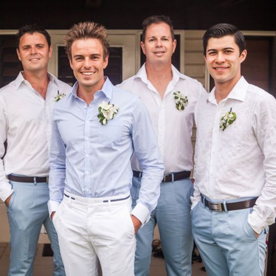 white pants, a light blue shirt and a floral boutonniere