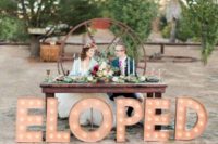 36 industrial wedding, a sweetheart table with ELOPED letters