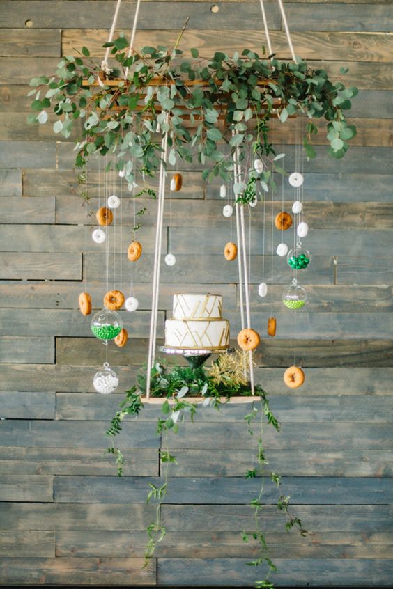 suspended cake display with greenery, donuts and candies for a fun touch