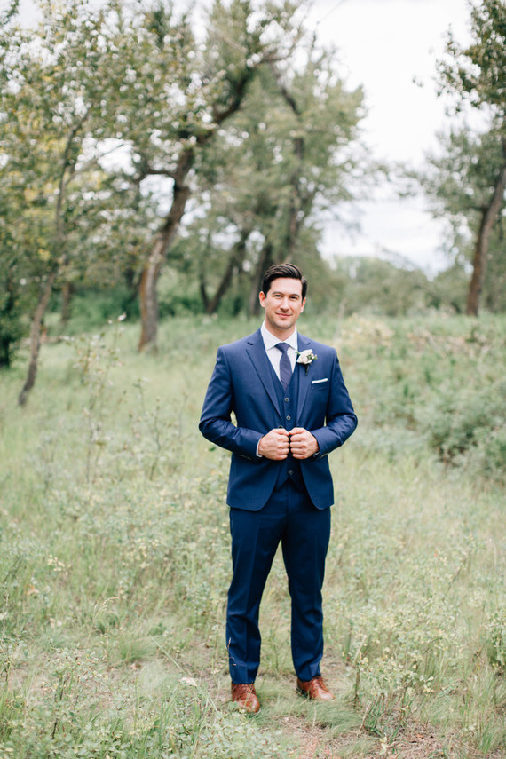 The groom was wearing a stylish navy suit with a vest and tie and ocher shoes for a stylish look