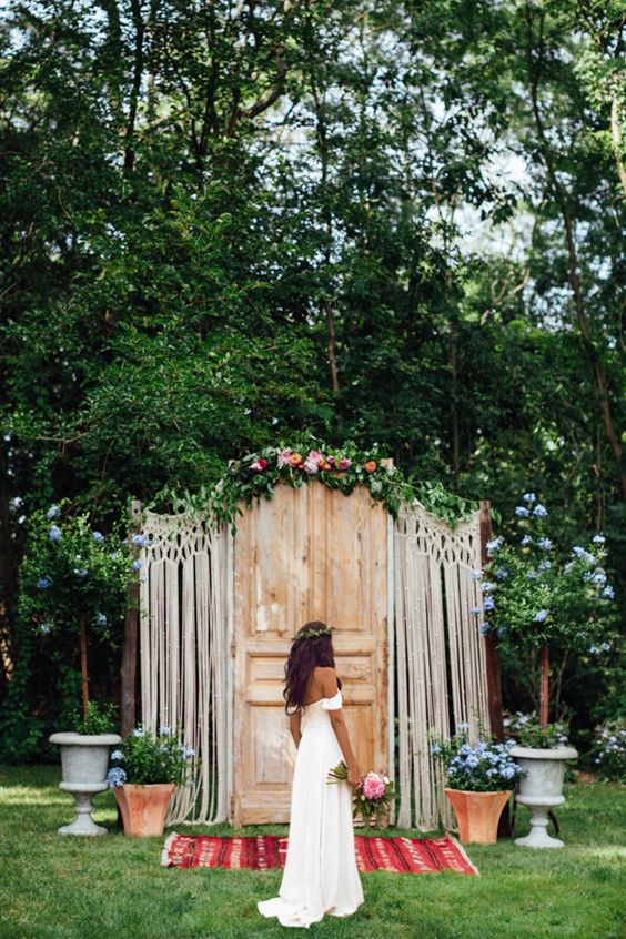a door backdrop with macrame decor, flowers and a bold rug