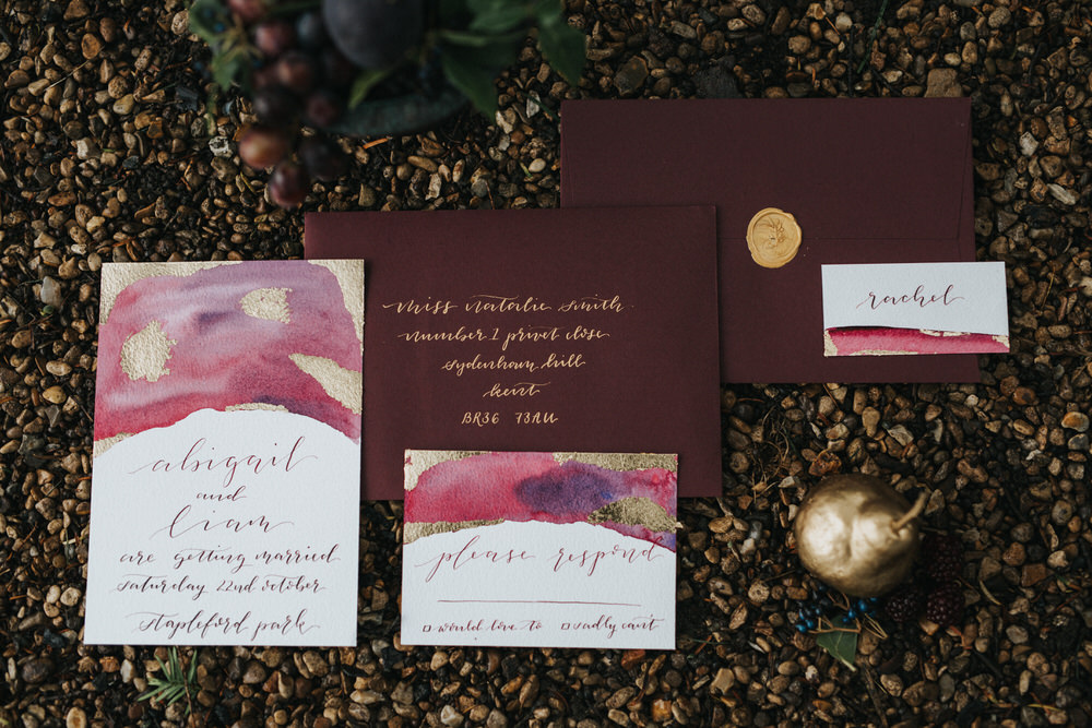 The wedding stationary was moody burgundy with gold touches