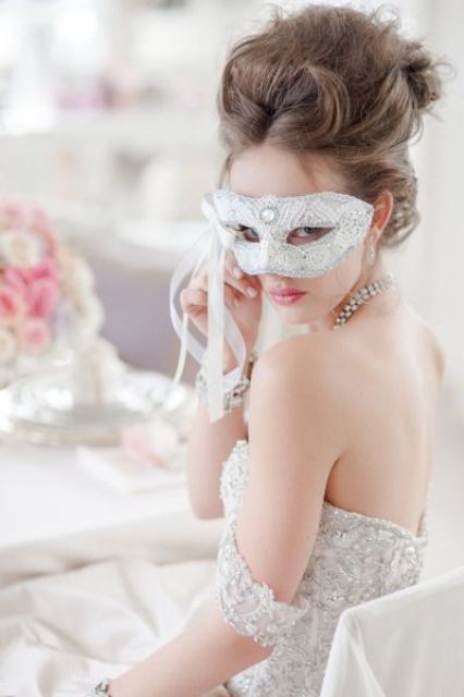 a white lace and rhinestone mask for the bride looks gorgeous