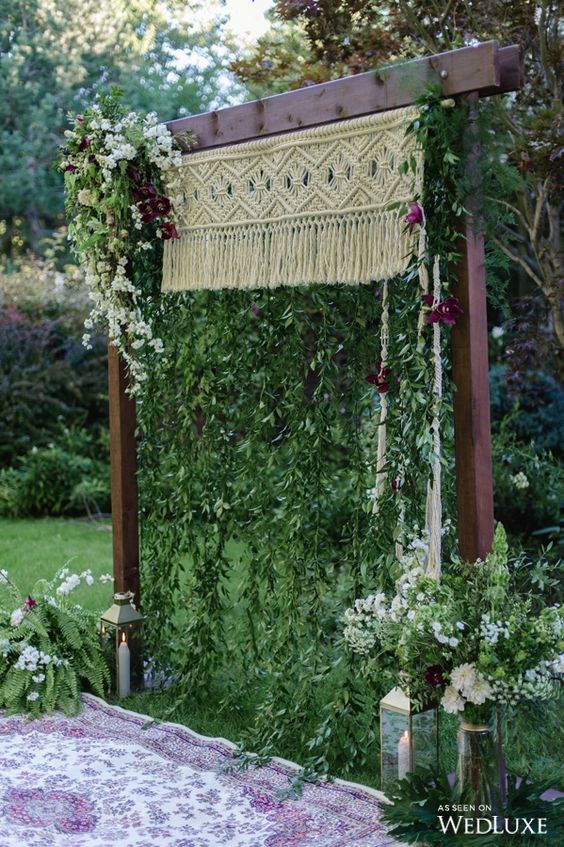 arch with macrame, hanging greenery and bold flowers