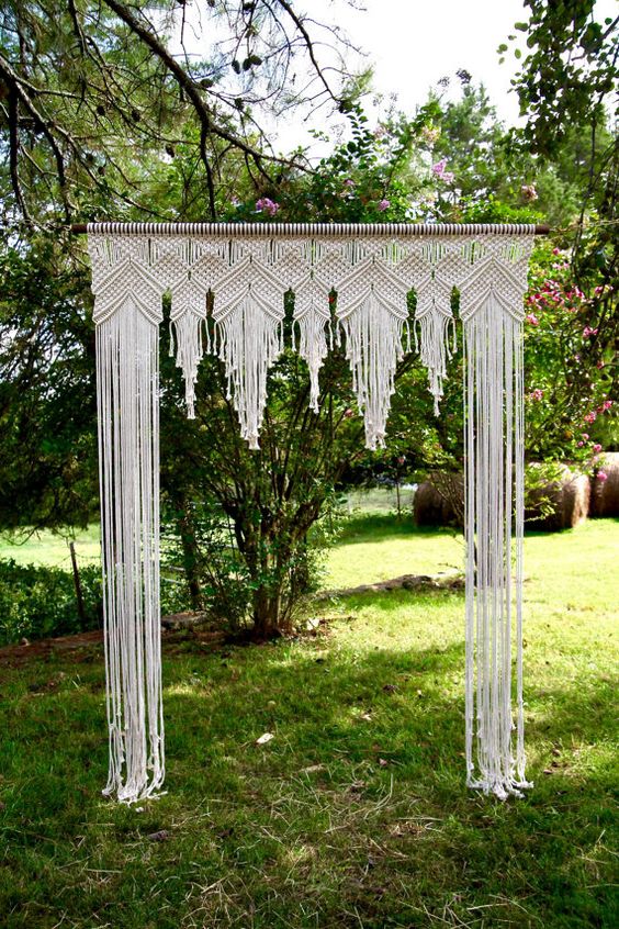 macrame covered wedding arch looks boho and gypsy at the same time
