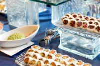 10 glass stands with various types of sushi and bowls with sauces