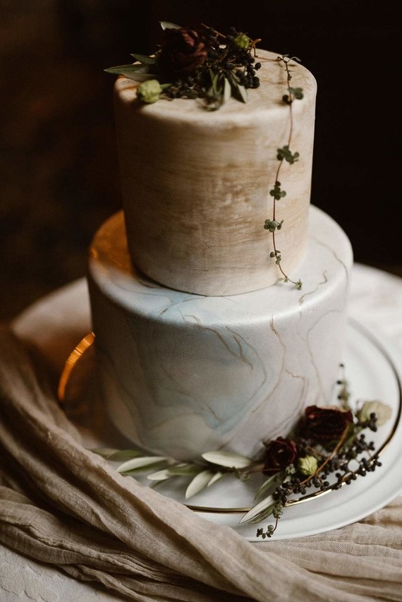 The hand painted marble wedding cake was topped with flowers