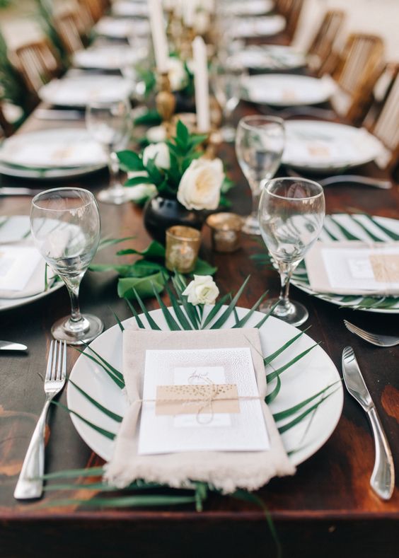 stylish table setting with palm leaves and neutral flowers