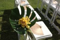 12 a simple pop of color with monstera leaves and orchids line the aisle with fans to help keep guest cool