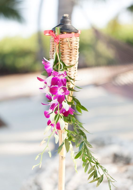 a torch with bold purple orchids and greenery