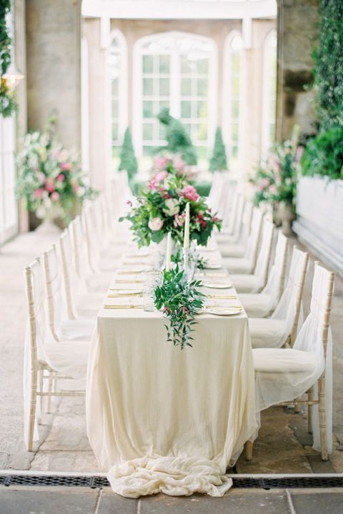 neutral wedding tablescape with lots of greenery and candles