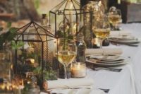 18 tablescape with greenery in lanterns, candles and a white tablecloth