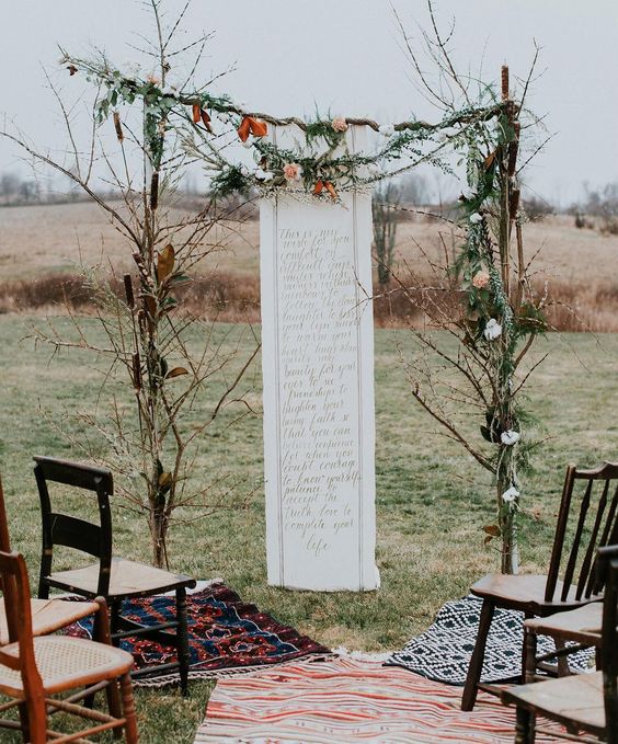 branch wedding arch with leaves and a quote backdrop