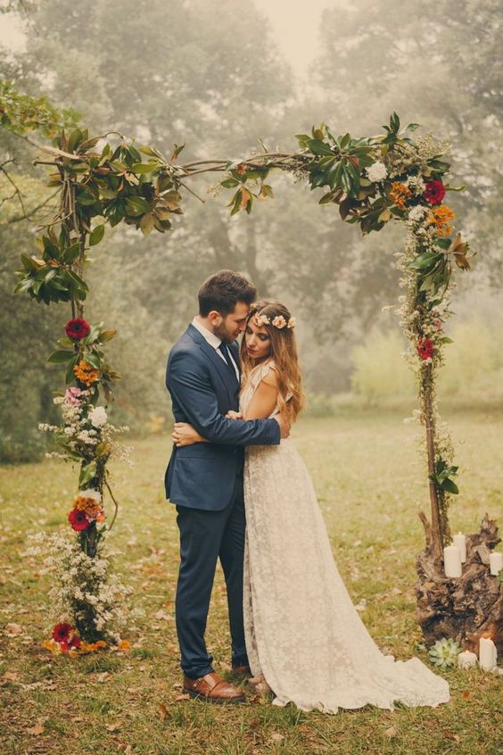 branch wedding arch with leaves and bold flowers for a fall wedding