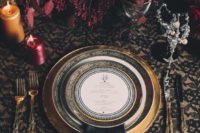 21 rock blood-colored florals, black napkins and gilded details for a refined tablescape