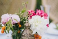 22 a centerpiece with a lantern, camel, fruits and flowers