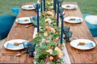 22 outdoor boho picnic with blues and a lush floral garland