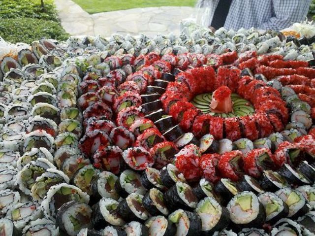 lush sushi station with all kinds of sushi placed on each other