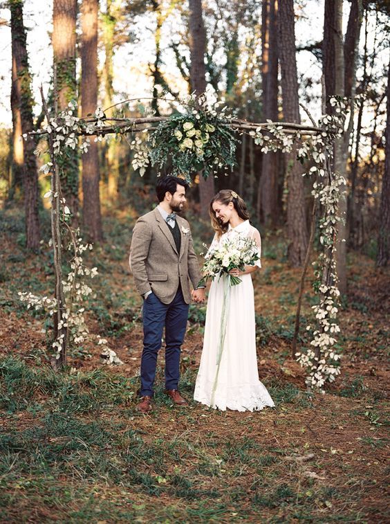 boho rough wood wedding arch with greenery and leaves for a fall wedding