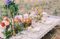 24 outdoor picnic tablescape with a crochet lace tablecloth, candle sticks and flowers