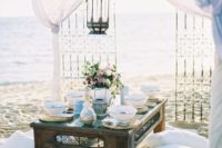 26 a boho picnic with a low table, a hanging lantern over it